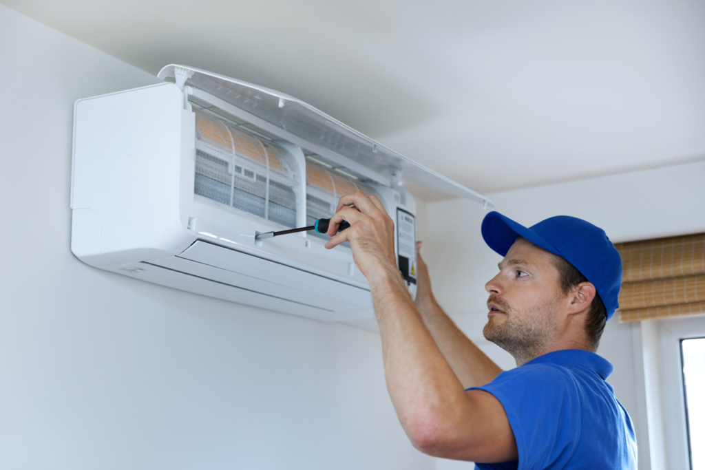 A man fixing a vent inside a home