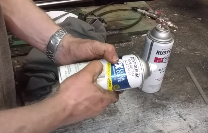 feeling the sides of a spray paint can for pressure