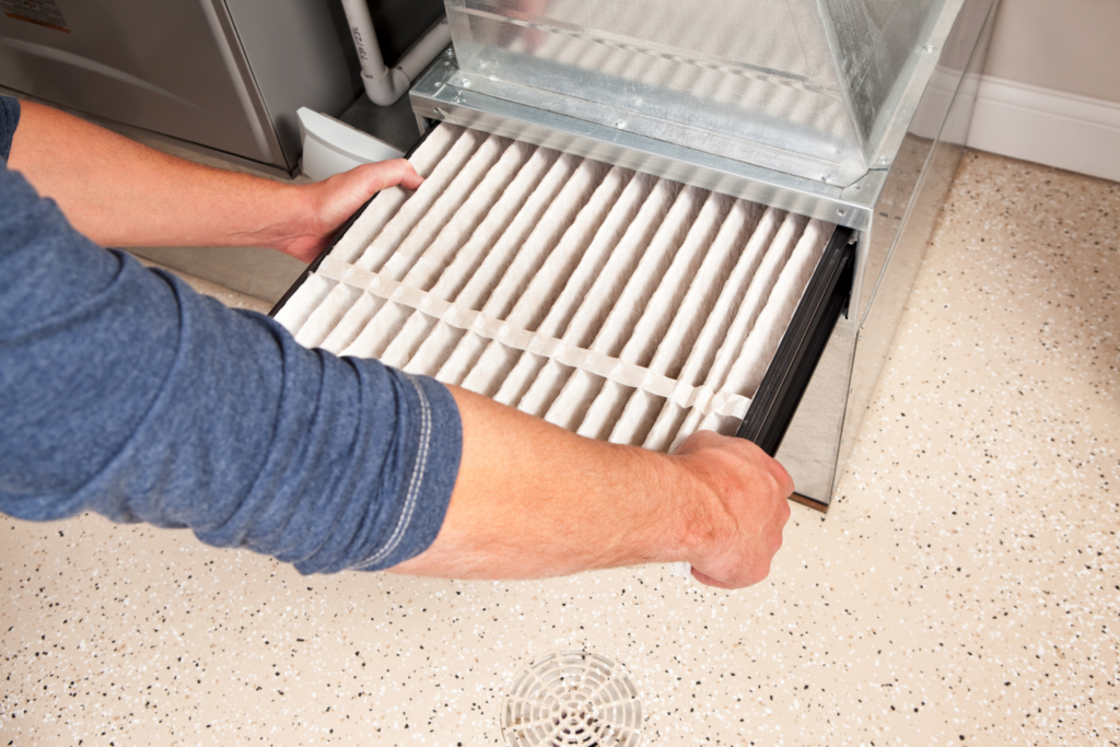 A person replacing an HVAC filter