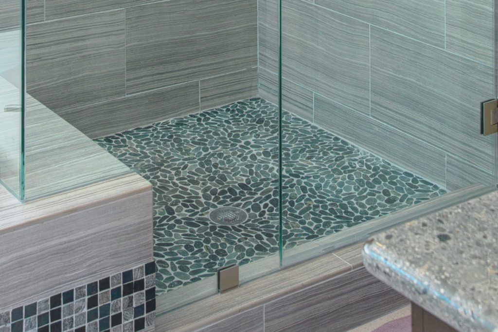 Pebble shower floors come in a variety of colors, shapes, and sizes and can work with many different design styles.