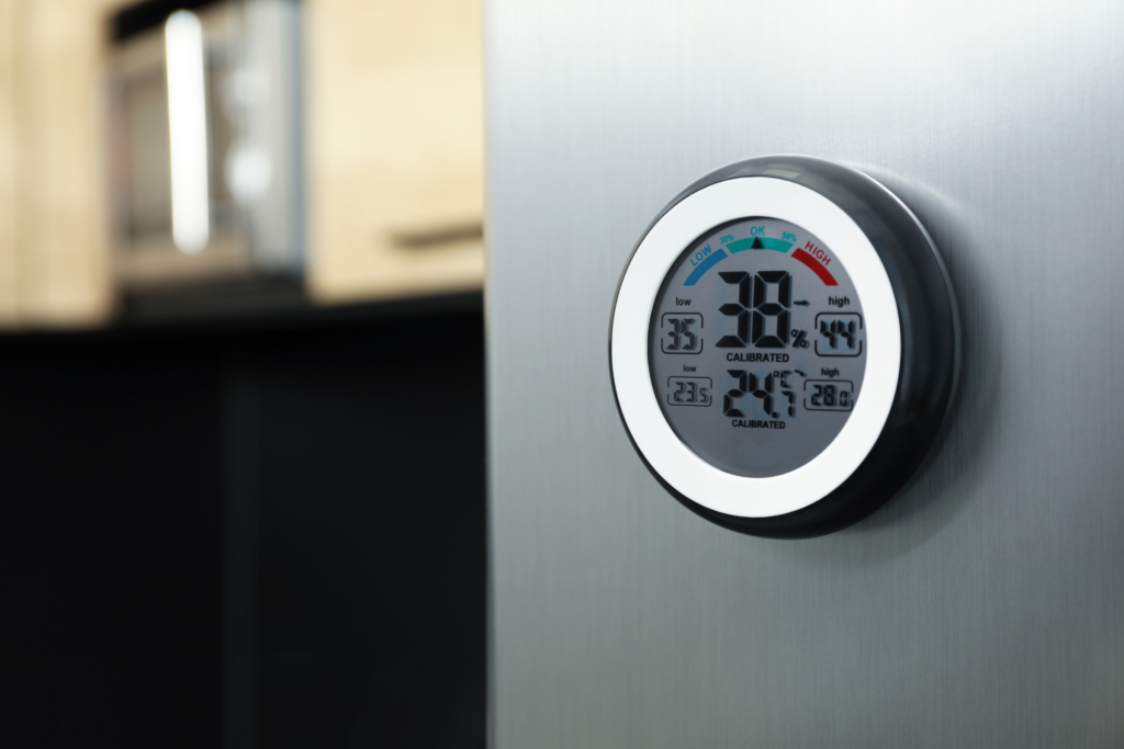 A thermostat on the outside of a mini fridge set to 38 degrees Farenheit.