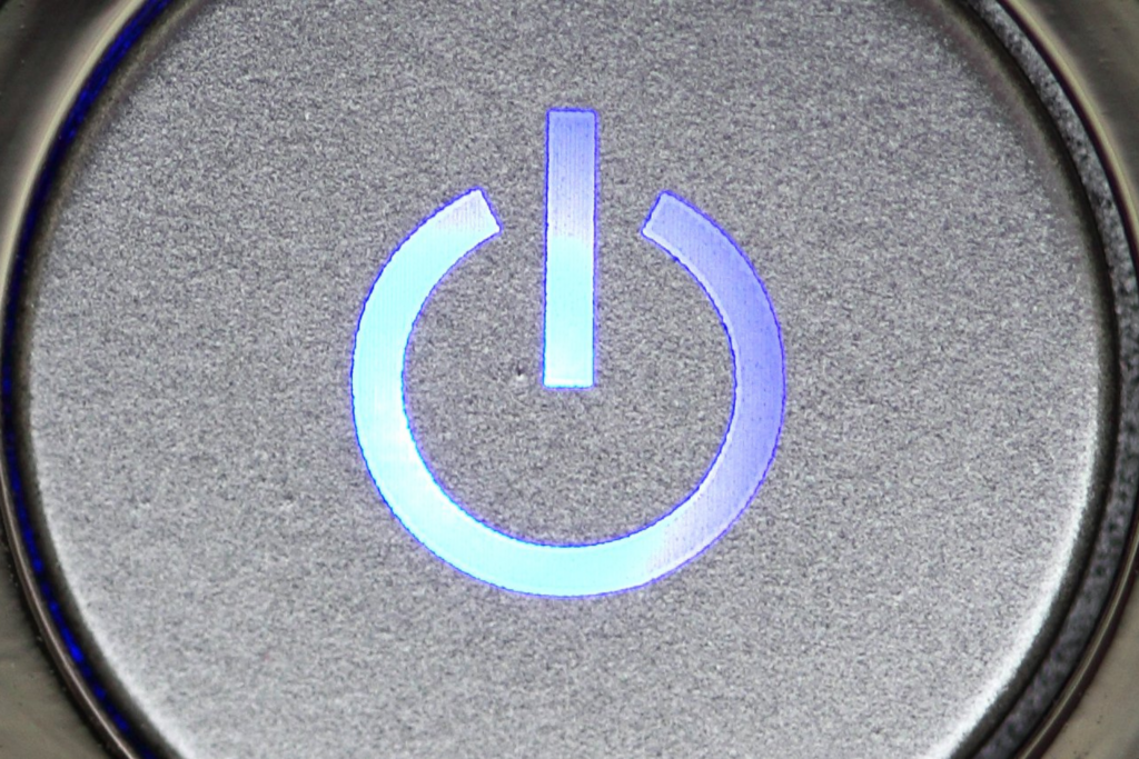 A glowing blue power symbol on a gray button.