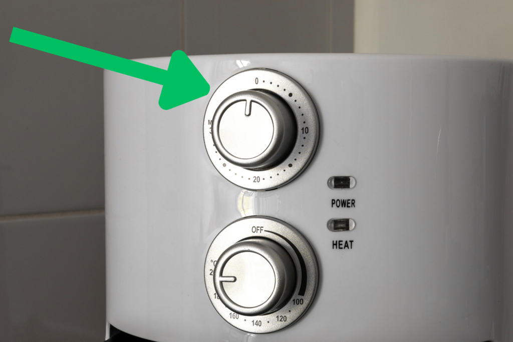 A green arrow points to a an air fryer timer dial.