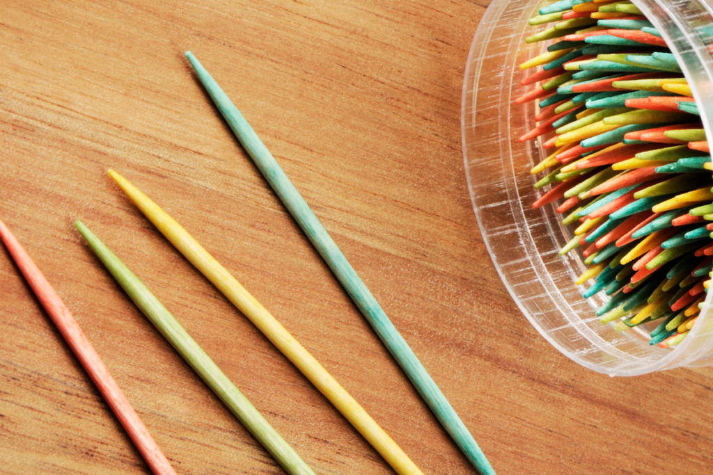 Colored toothpicks are food safe, but are better left for decorating than being used in the cooking process.