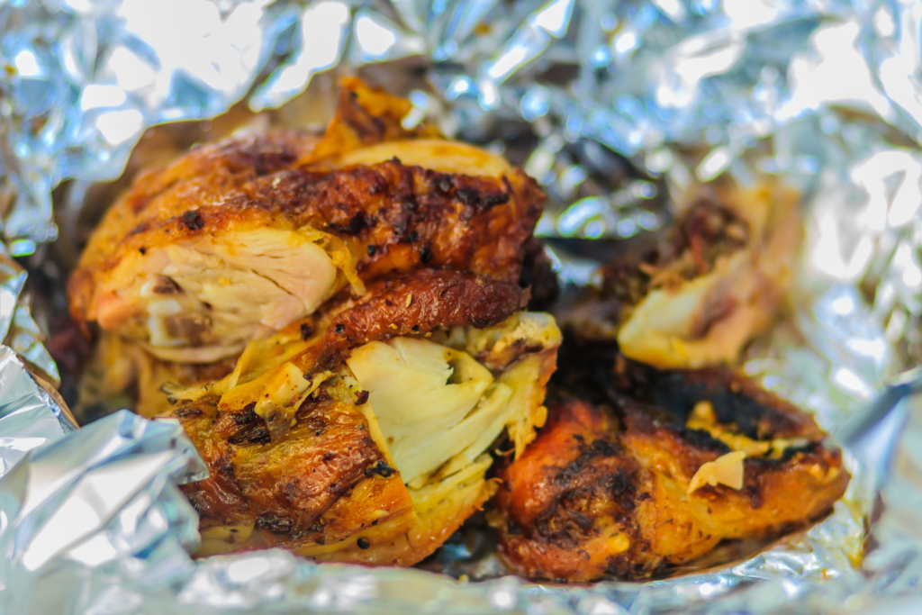 Cooked chicken sits inside aluminum foil.