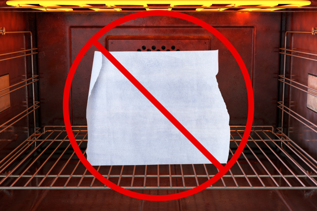 A piece of freezer paper inside an oven with a red "prohibited" sign overtop of it.