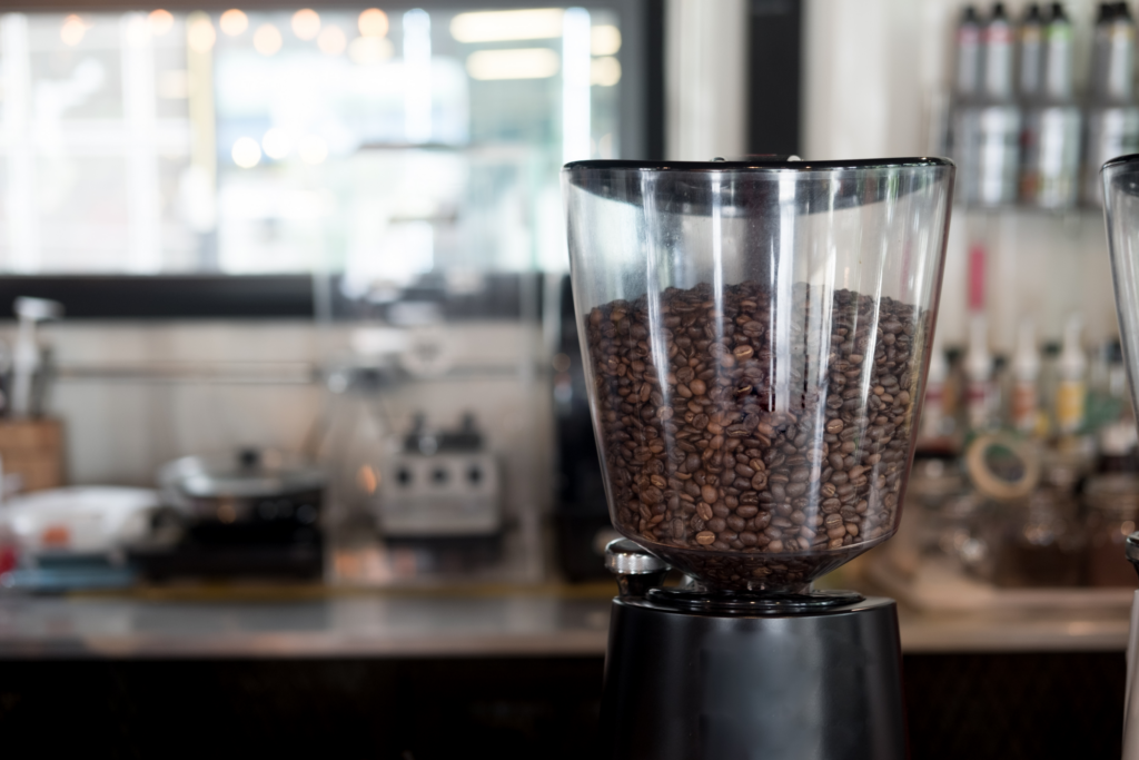 A burr coffee grinder filled with coffee beans 