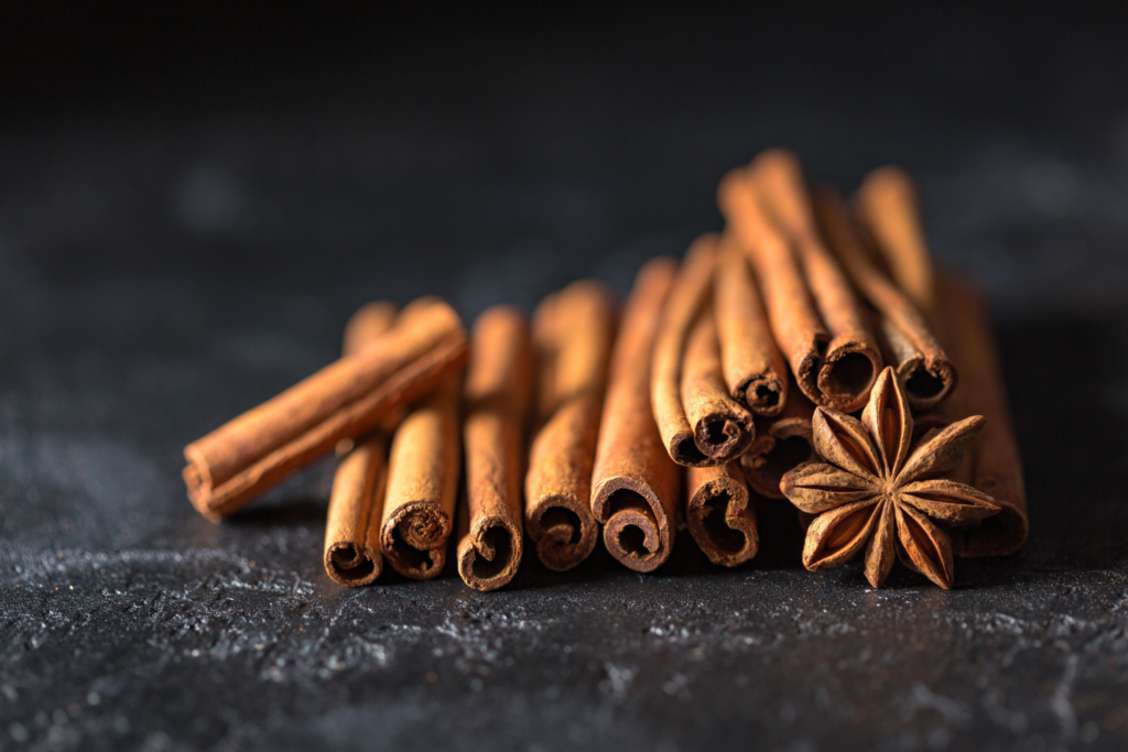 Up-close image of cinnamon sticks and one star anise in the bottom right corner