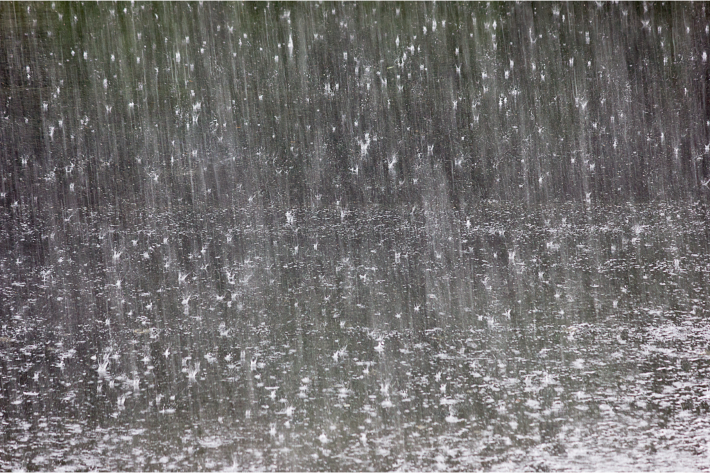 When it starts raining you may wonder, "Will rain damage a window air conditioner?" and the answer is no! This photo depicts heavy rain hitting a lake. It is dark.