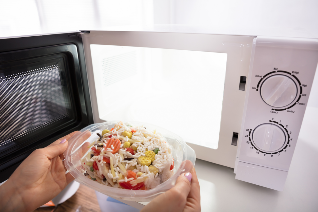 plastic tupperware being used to reheat food in microwave