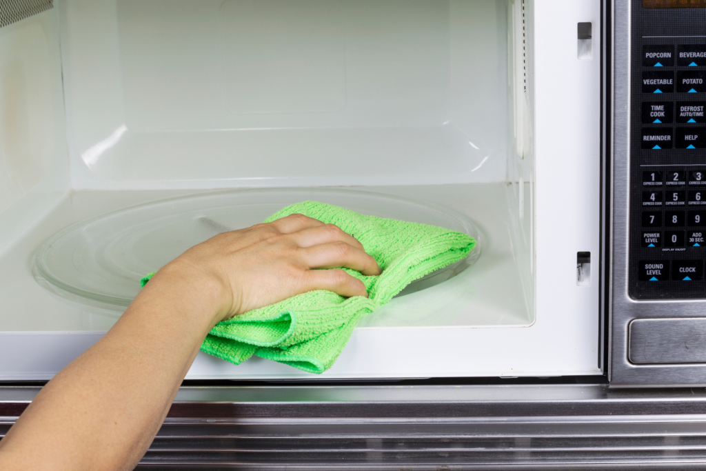 cleaning a microwave with a microfiber towel