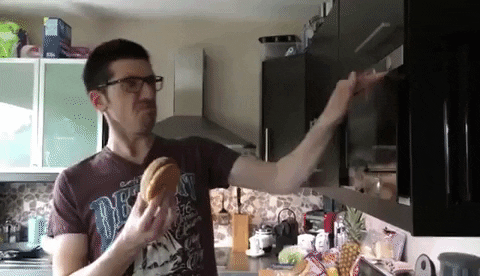 guy throwing a hamburger into the microwave and slamming it close